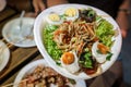 Somtum; Spicy papaya salad with pickled fish in paper dish at foodtruck street food event., Bangkok, Thailand