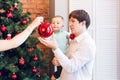 Son and dad decorating the christmas tree at home in the living room Royalty Free Stock Photo