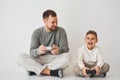 Son and dad play console games with gamepad. Boy and his father spend time togerher and playing computer games. Royalty Free Stock Photo