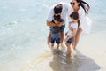 Son and daughter run on the water and splash on their smiling parents Royalty Free Stock Photo