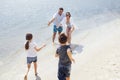 Son and daughter run on the water and splash on their smiling parents Royalty Free Stock Photo