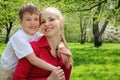 Son embraces behind mother in park