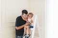 The son embraces the beloved daddy. Little boy is sitting on a step-ladder Royalty Free Stock Photo