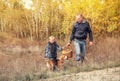 Son with father carry full basket of mushrooms in autumn forest