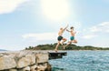 Son with Father having a fun on a merry vacation days on Adriatic sea coast. They dressed swimming trunks jumping to the waives Royalty Free Stock Photo
