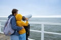 son and father look through coin binoculars at the cold sea. Royalty Free Stock Photo