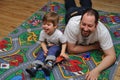 Son and father playing with toys on carpet Royalty Free Stock Photo