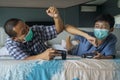 Son and father playing video game with medical mask Royalty Free Stock Photo