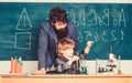 Son and father at school. small boy with teacher man. Wisdom. Back to school. Pharmacy and chemistry theme. solution in Royalty Free Stock Photo