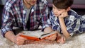 Son and father spending time together reading interesting book, divorced parents