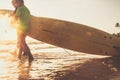 Son and father surfers walk in ocean waves with boards Royalty Free Stock Photo