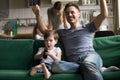 Son with father watching football on TV together