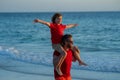 Son on fathers shoulders piggyback ride. Father and son walking together on the beach. Fatherhood family concept. Travel