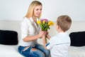 Son gives his beloved mother a beautiful bouquet of tulips.