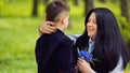 The son gives his mother a fresh bouquet of blue muscari flowers on a bench in the park. Royalty Free Stock Photo