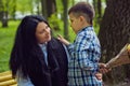 The son gives his mother a fresh bouquet of tulips flowers on a bench in the park. Royalty Free Stock Photo