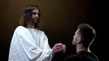 Son of God holding hands of praying man, spiritual support, absolution of sins Royalty Free Stock Photo