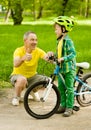 Son and grandfather having fun riding a bike Royalty Free Stock Photo