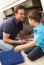 Son Helping Father To Mend Sink