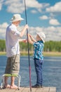 Son helps his father to fish Royalty Free Stock Photo