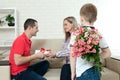 Son hiding bouquet to surprise mommy on mother`s day. Woman, man Royalty Free Stock Photo