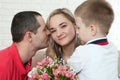 Son hiding bouquet to surprise mommy on mother`s day. Woman, man Royalty Free Stock Photo