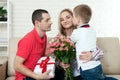 Son hiding bouquet to surprise mommy on mother`s day. Woman, man Royalty Free Stock Photo