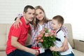 Son hiding bouquet to surprise mommy on mother`s day. Woman, man Royalty Free Stock Photo