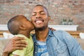 Son kissing his father on the couch Royalty Free Stock Photo