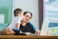 Son kissing his father while using internet. People and Lifestyles concept. Technology and Happy family theme. Single dad theme