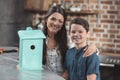 Little son and his beautiful mother smiling while looking at finished birdhouse