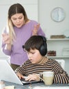 Son plaing video games having quarrel with unhappy mom Royalty Free Stock Photo