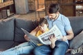 Son reading newspaper to father at home Royalty Free Stock Photo