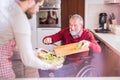 Son and senior father in wheelchair cooking in the kitchen. Royalty Free Stock Photo