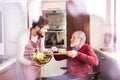 Son and senior father in wheelchair cooking in the kitchen. Royalty Free Stock Photo