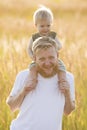 Son sits on the shoulders of his happy father Royalty Free Stock Photo