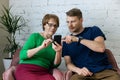 Son teach his mother to use mobile phone. senior woman learning to use modern technologies