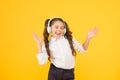 The song clicks with her mood. Adorable little girl singing a song on yellow background. Cute small child listening to Royalty Free Stock Photo