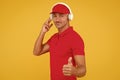 This song is so good. Unshaven man give thumbs up yellow background. Like and approval sign. Handsome guy listen to song Royalty Free Stock Photo