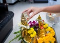 Songkran day, Thai culture concept, Hand woman use the sliver blow to golden buddha statue Royalty Free Stock Photo
