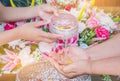 Songkran festival sign of Thailand : Hand of young people pour water, flowers on older. Thais celebrate Songkran in new year water Royalty Free Stock Photo