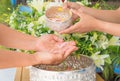 Songkran festival sign of Thailand : Hand of young people pour water, flowers on older. Thais celebrate Songkran in new year water Royalty Free Stock Photo