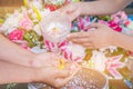 Songkran festival sign of Thailand : Hand of young people pour water, flowers on older. Thais celebrate Songkran in new year water Royalty Free Stock Photo