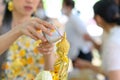 Songkran festival, Thai New Year. female hand holding silver bowl pouring water with jasmine and roses onto buddha statue Royalty Free Stock Photo