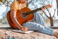 Songwriter create and writing notes,lyrics in the book on stone at parks Royalty Free Stock Photo