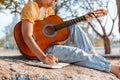 Songwriter create and writing notes,lyrics in the book on stone at parks