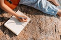 Songwriter create and writing notes,lyrics in the book on stone at parks Royalty Free Stock Photo