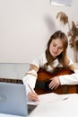 Songwriter thinking and writing notes at home. Woman playing live acoustic guitar. Artist composer in work process. Royalty Free Stock Photo