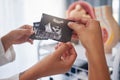 Sonogram, showing and hands with an ultrasound of a baby from the doctor to mother at a clinic. Consultation, pregnancy Royalty Free Stock Photo