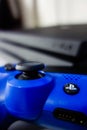 Sony black Playstation 4 Pro game console and blue wireless controller Royalty Free Stock Photo